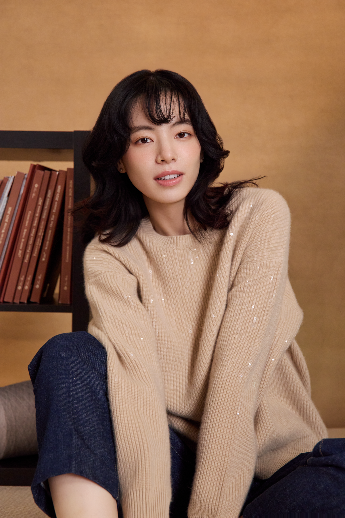 淺米色 Cashmere 亮片針織上衣與牛仔褲的坐姿穿搭